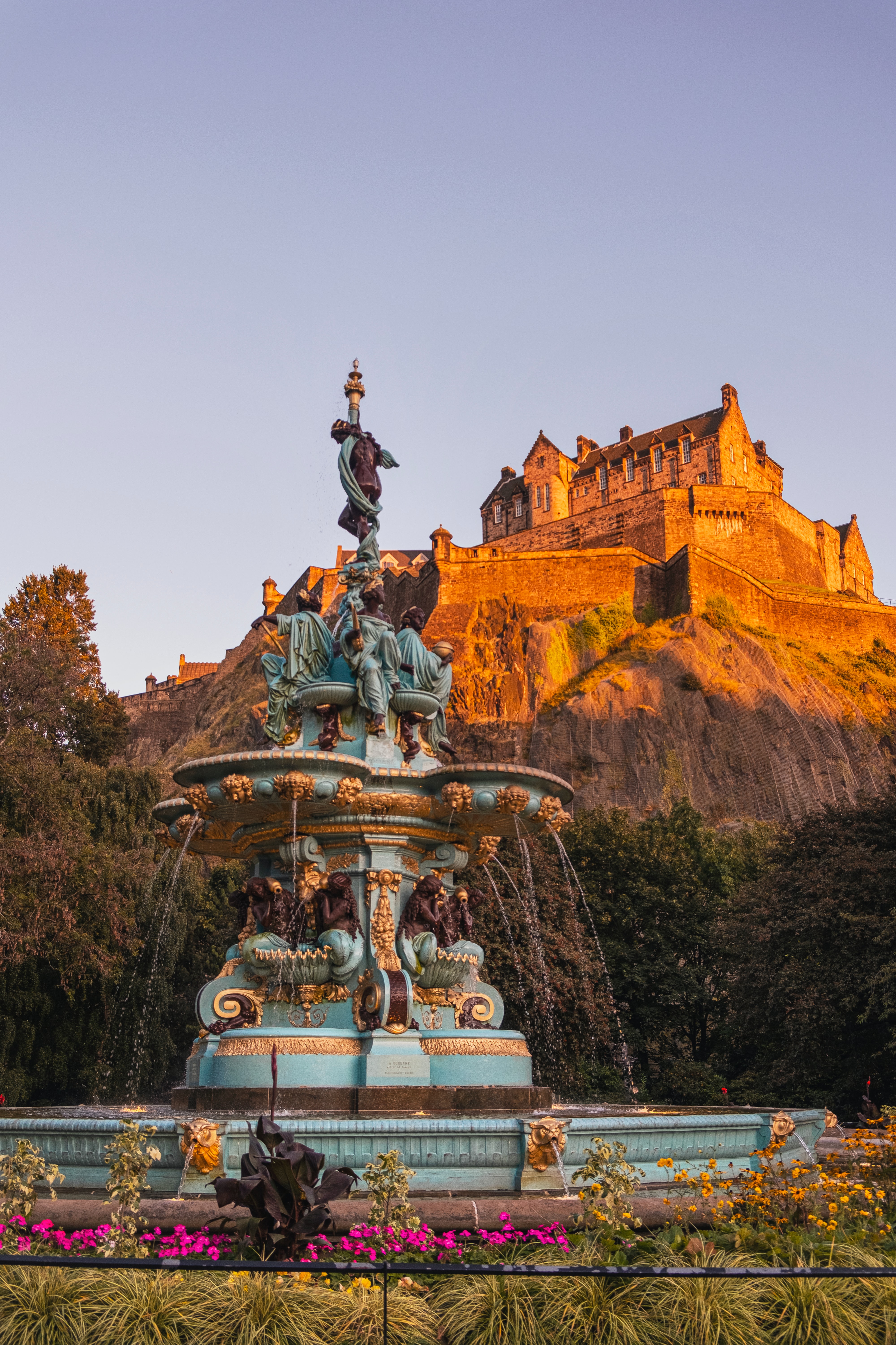 Ross Fountain in Princes Street Gardens with Edinburgh Castle behind at golden hour