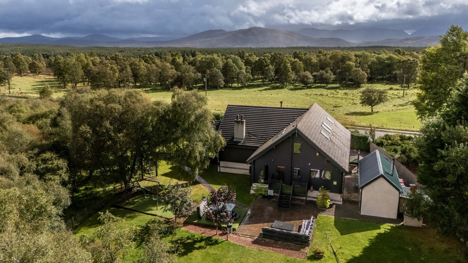 Aerial view of the lodge set among woodland and grounds in the Cairngorms