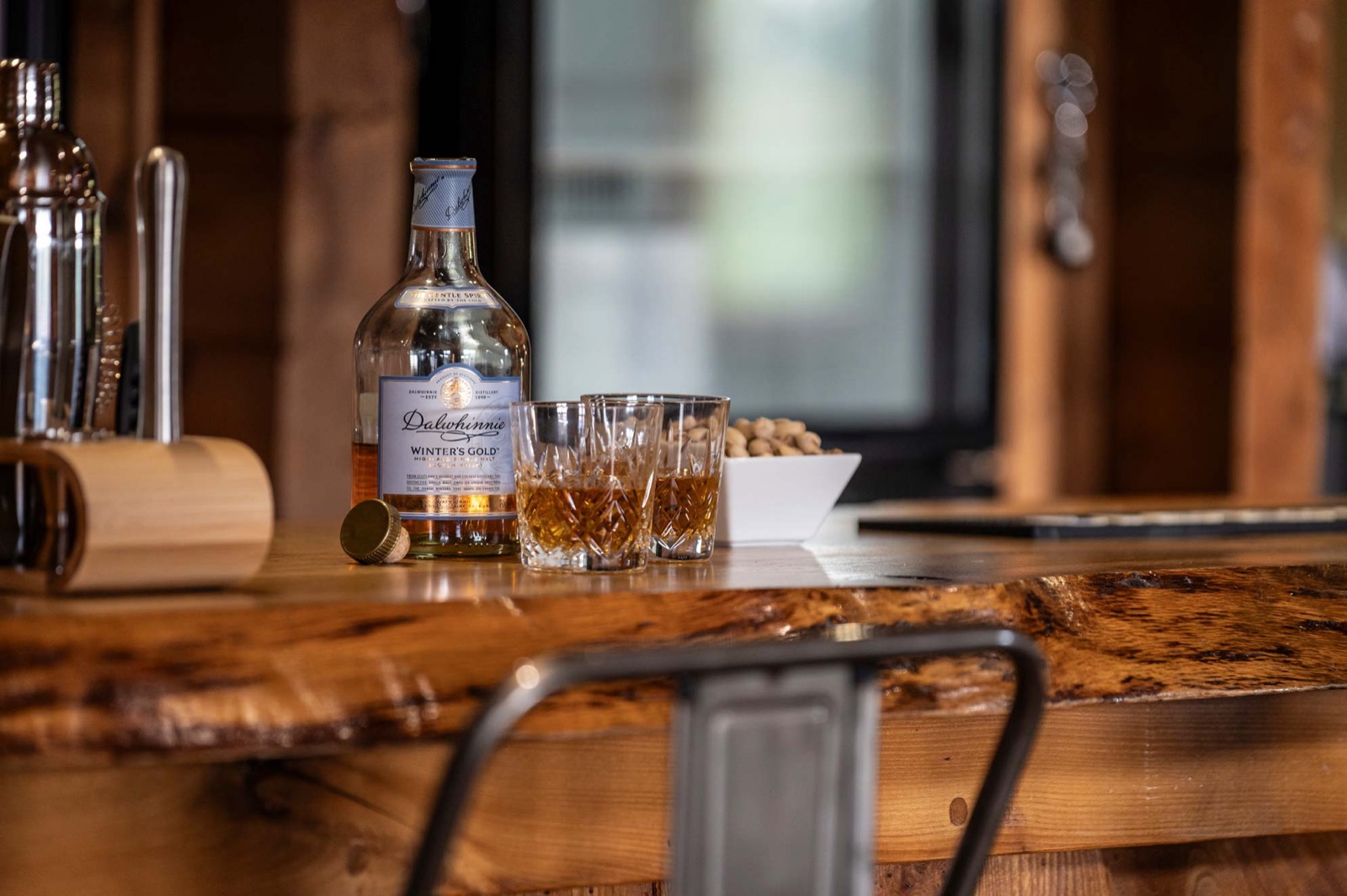 Spirits and glasses set out on the wooden bar top