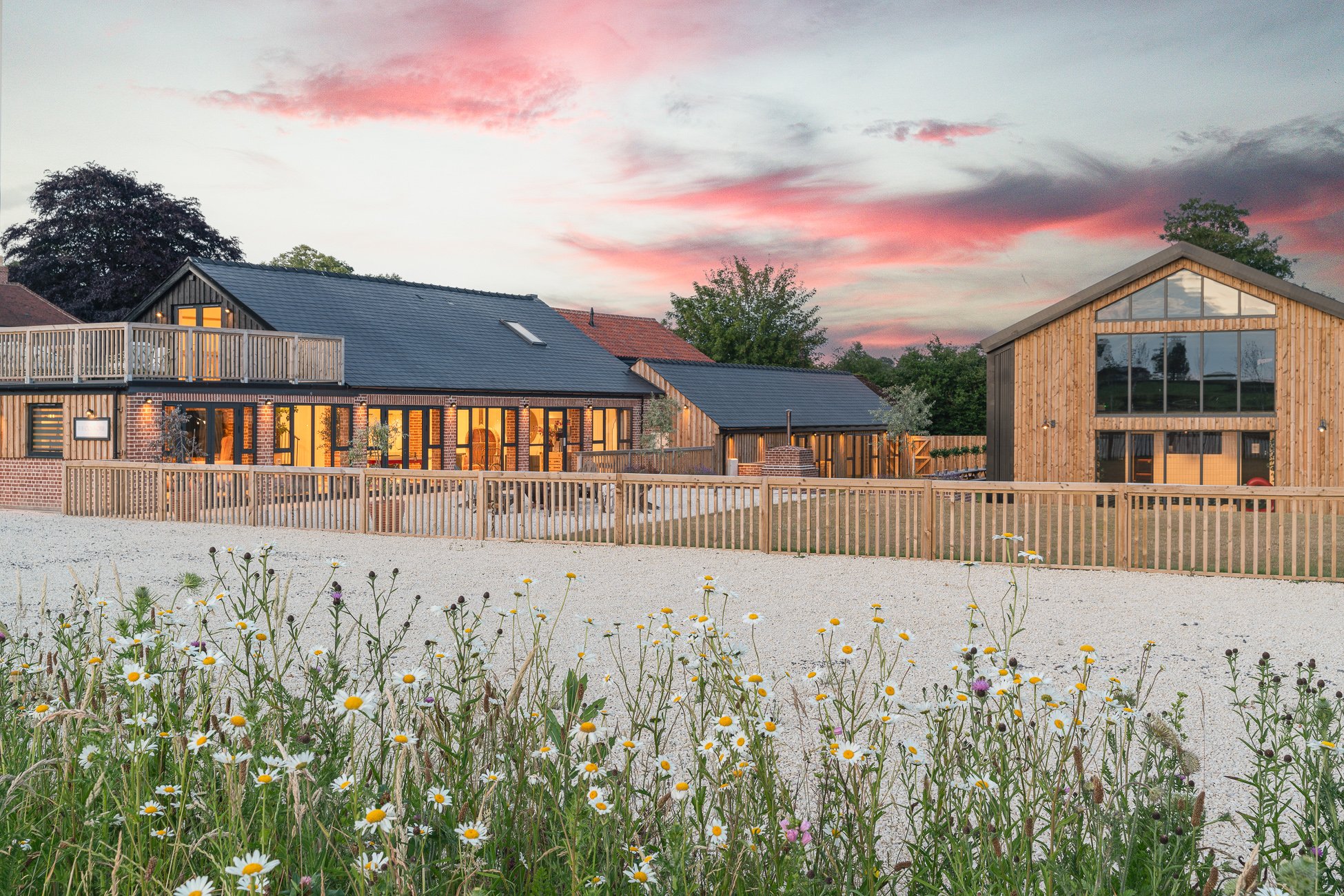 Bridgertons barn cluster at golden hour with wildflower meadow, Bath