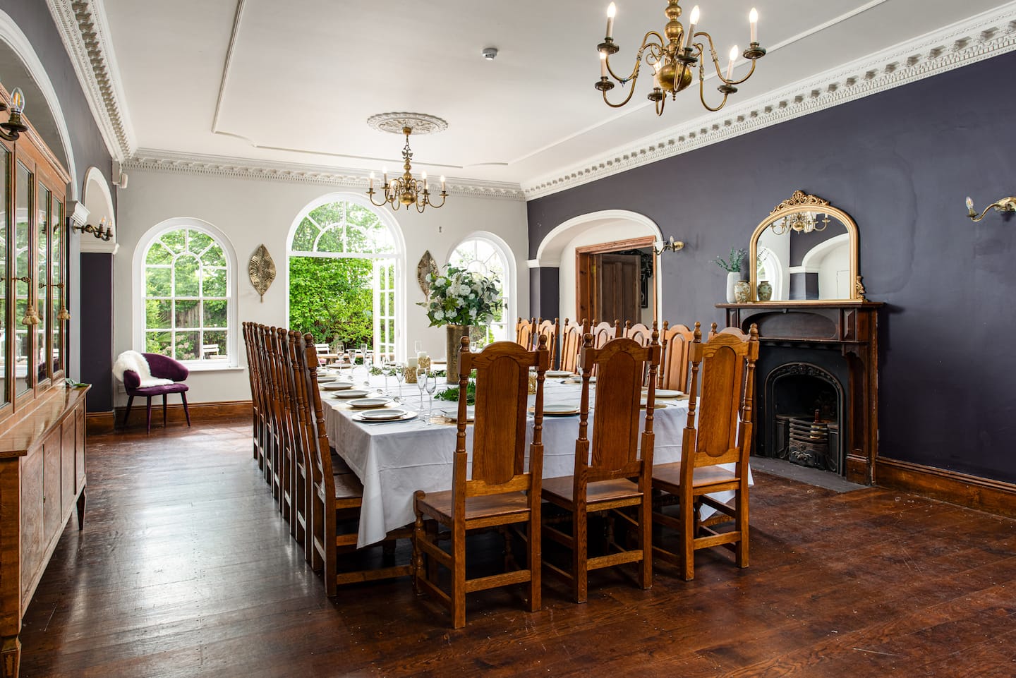 Formal dining room with a long table, chandelier and period fireplace