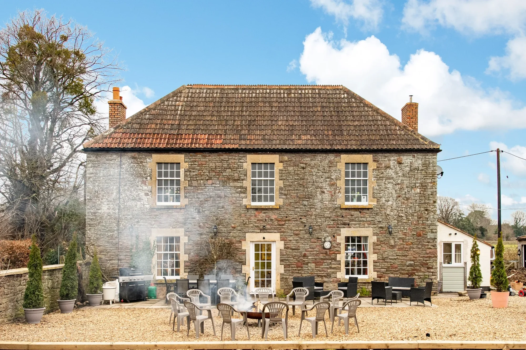 Flowering Farm rear exterior with garden firepit and steaming hot tub