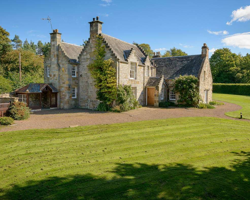 Georgian Cottage stone-built exterior with crow-stepped gables and front lawn on the castle estate