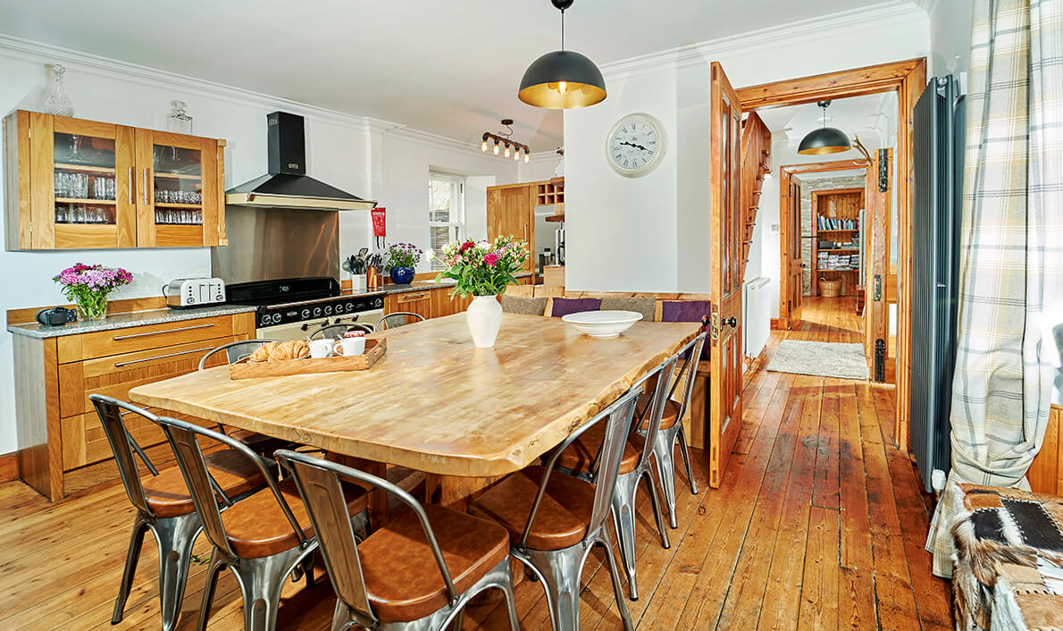 Country kitchen-diner with chunky pine table for ten, range cooker and metal bistro chairs