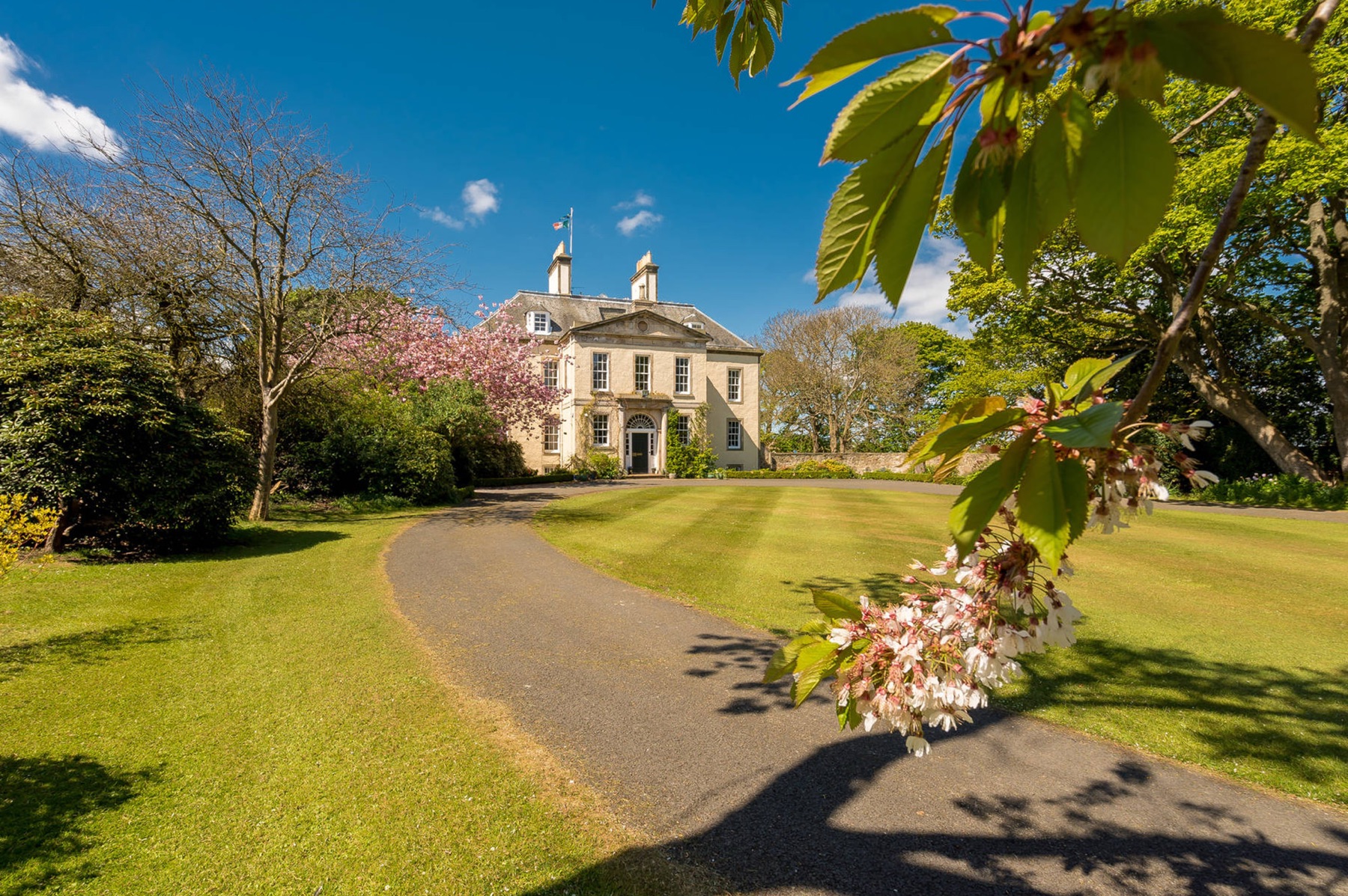 Luxury Oasis Georgian mansion exterior with cherry blossom and gravel sweep, Edinburgh