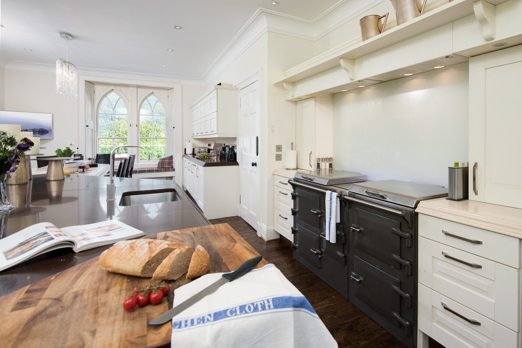 Black AGA-style range cooker and breadboard with cherry tomatoes in the kitchen, Sequoia House