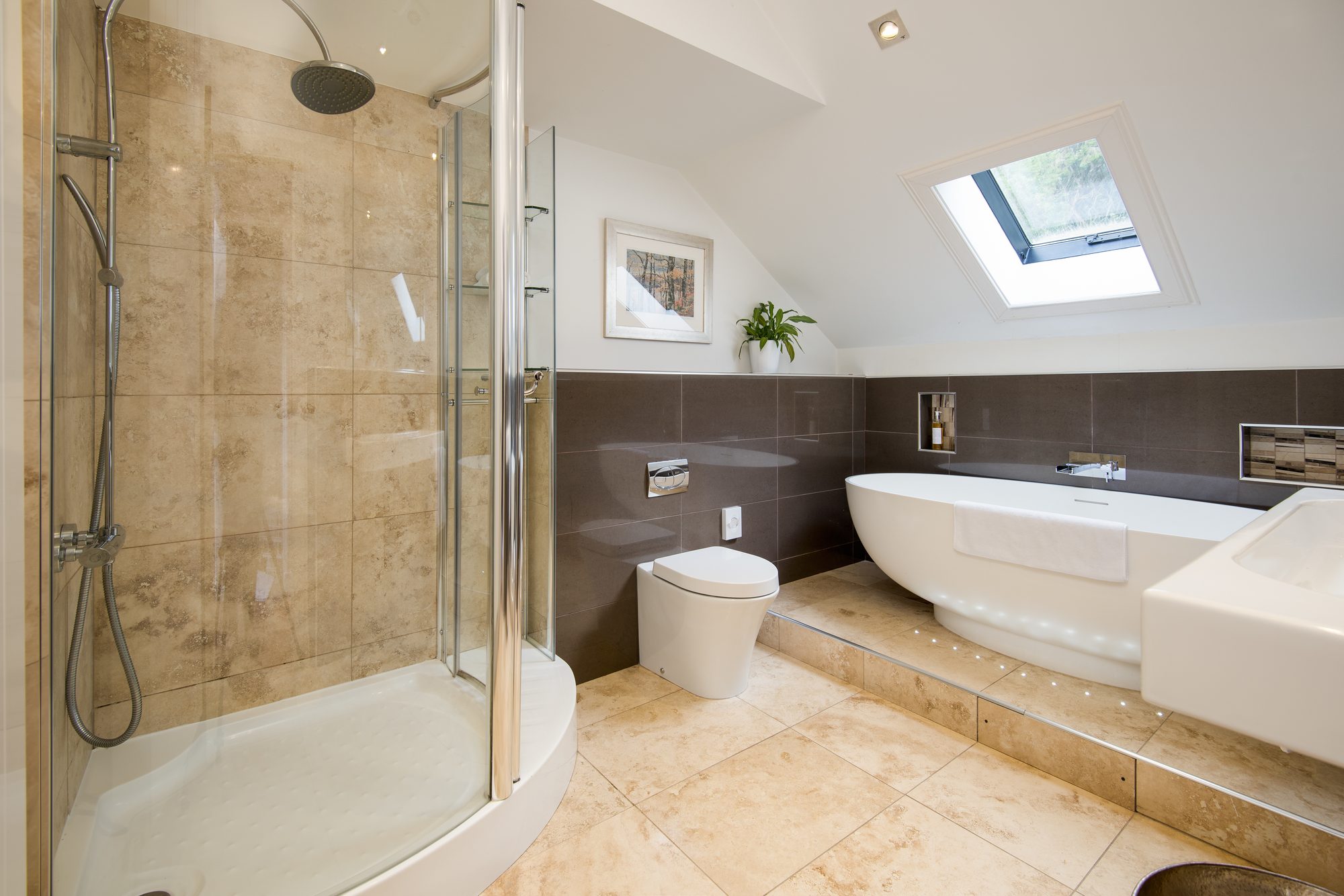 Spa bathroom with curved glass shower, freestanding tub on a lit plinth and a skylight, Sequoia House