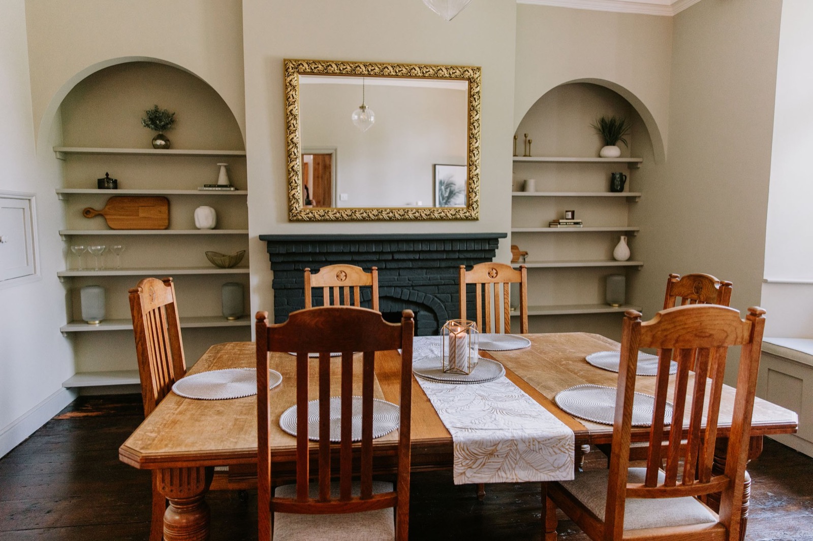 Dining room with a long wooden table, arched alcoves and a gilt mirror over the fireplace, The Old Farmhouse