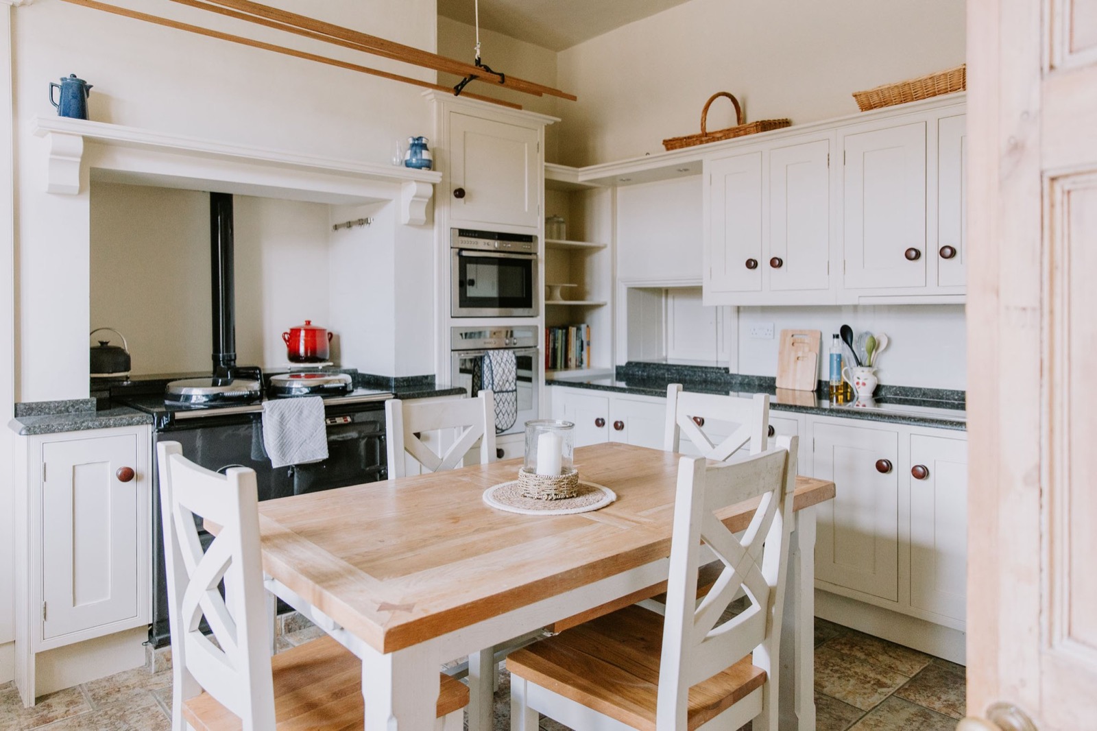 Farmhouse kitchen with cream cabinetry, Aga and a wooden table with cross-back chairs, The Old Farmhouse