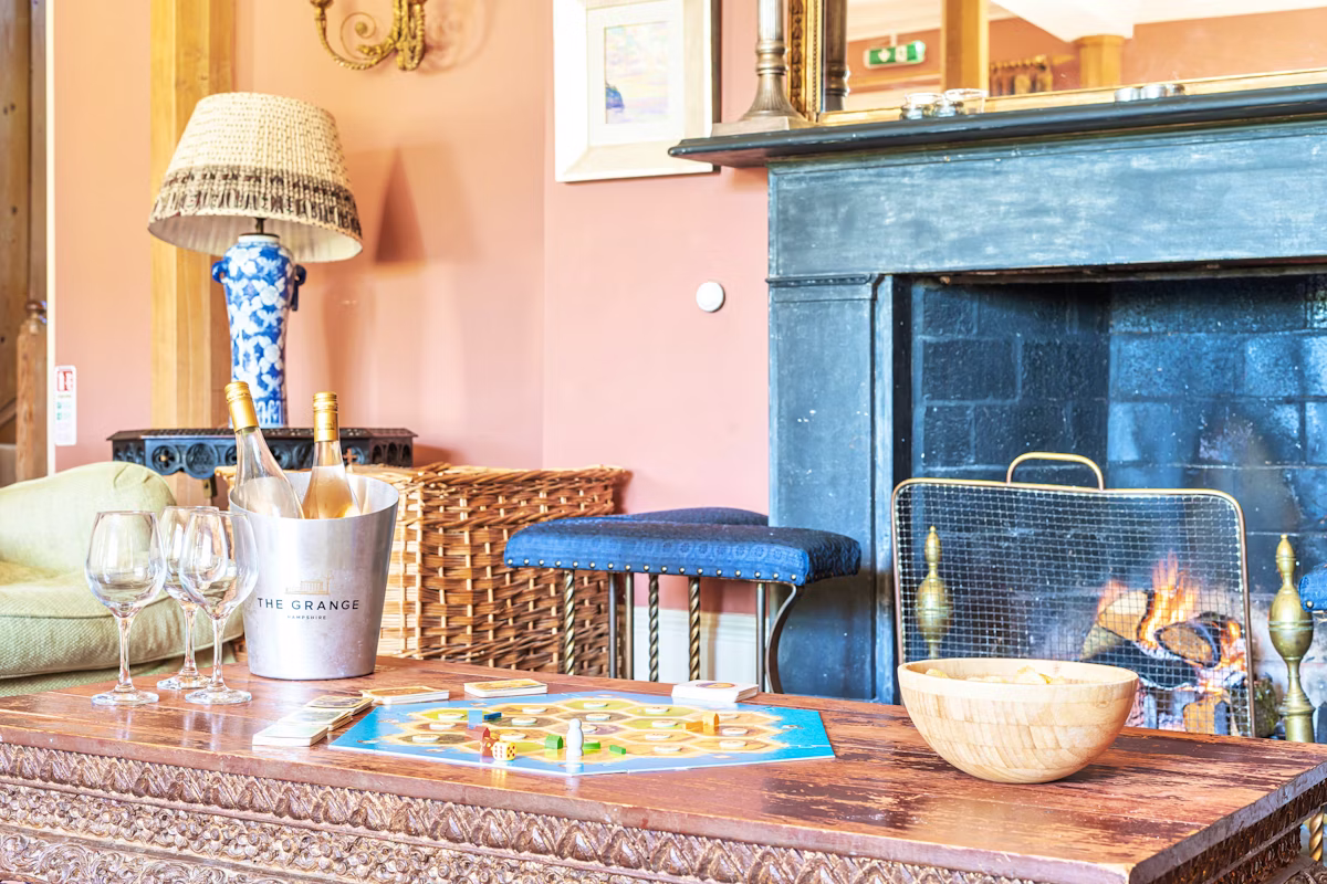 Cosy corner with black fireplace, blue ginger-jar lamp and a wicker log basket, The Country Social
