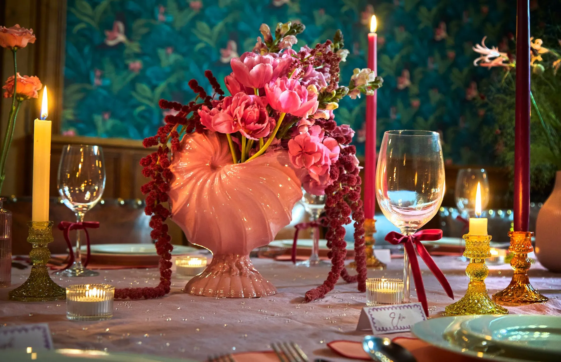 Dinner table dressed with a pink shell vase of peonies, taper candles in brass holders and crystal wine glasses, The Pretty Pub House