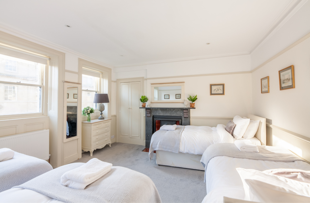 Family room with three single beds, black marble fireplace, French chest of drawers and twin sash windows, Tillie's Townhouse