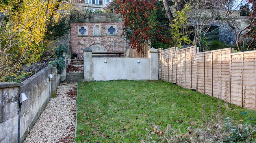 Walled garden with lawn, autumn trees and Bath stone retaining wall, Victorian Townhouse