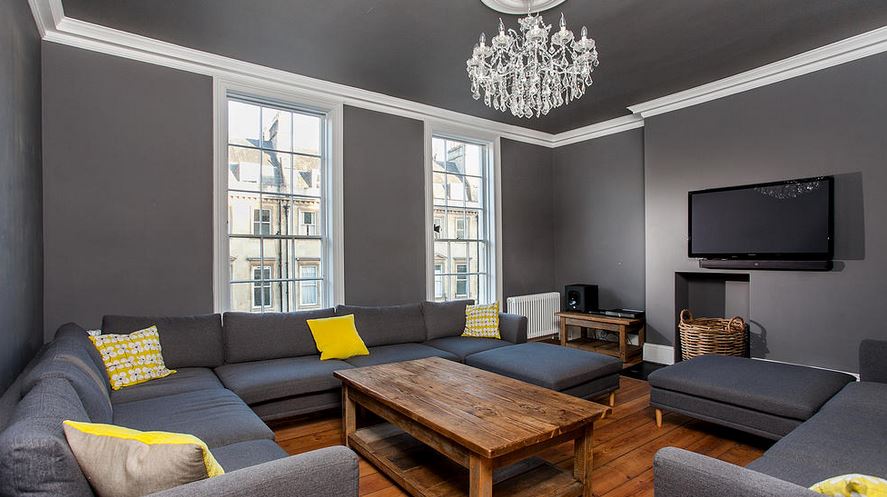 Grand grey lounge with chandelier, tall sash windows and corner sofa, Victorian Townhouse
