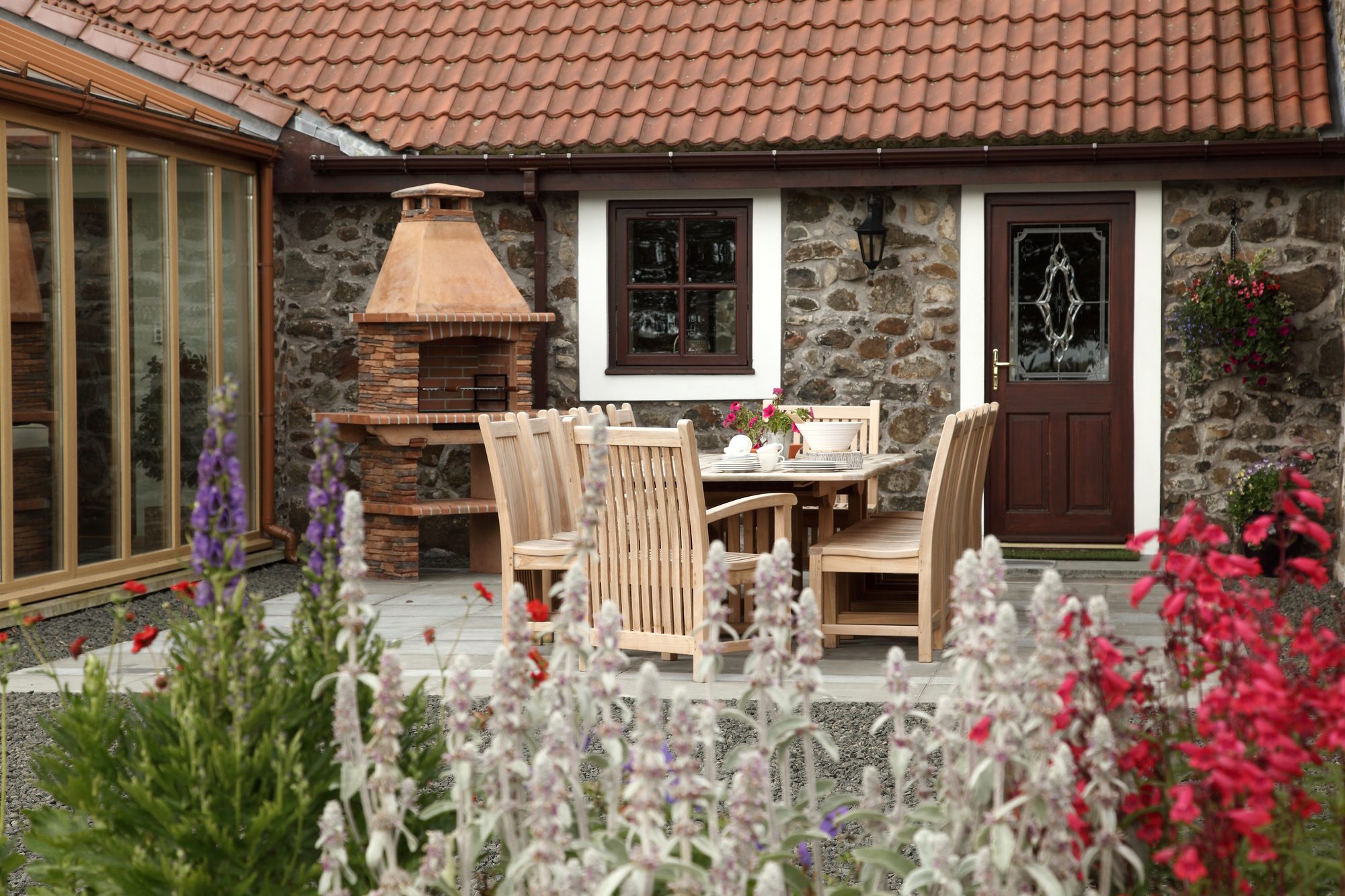 Writers Retreat garden courtyard with stone walls, dining table, BBQ and lavender borders