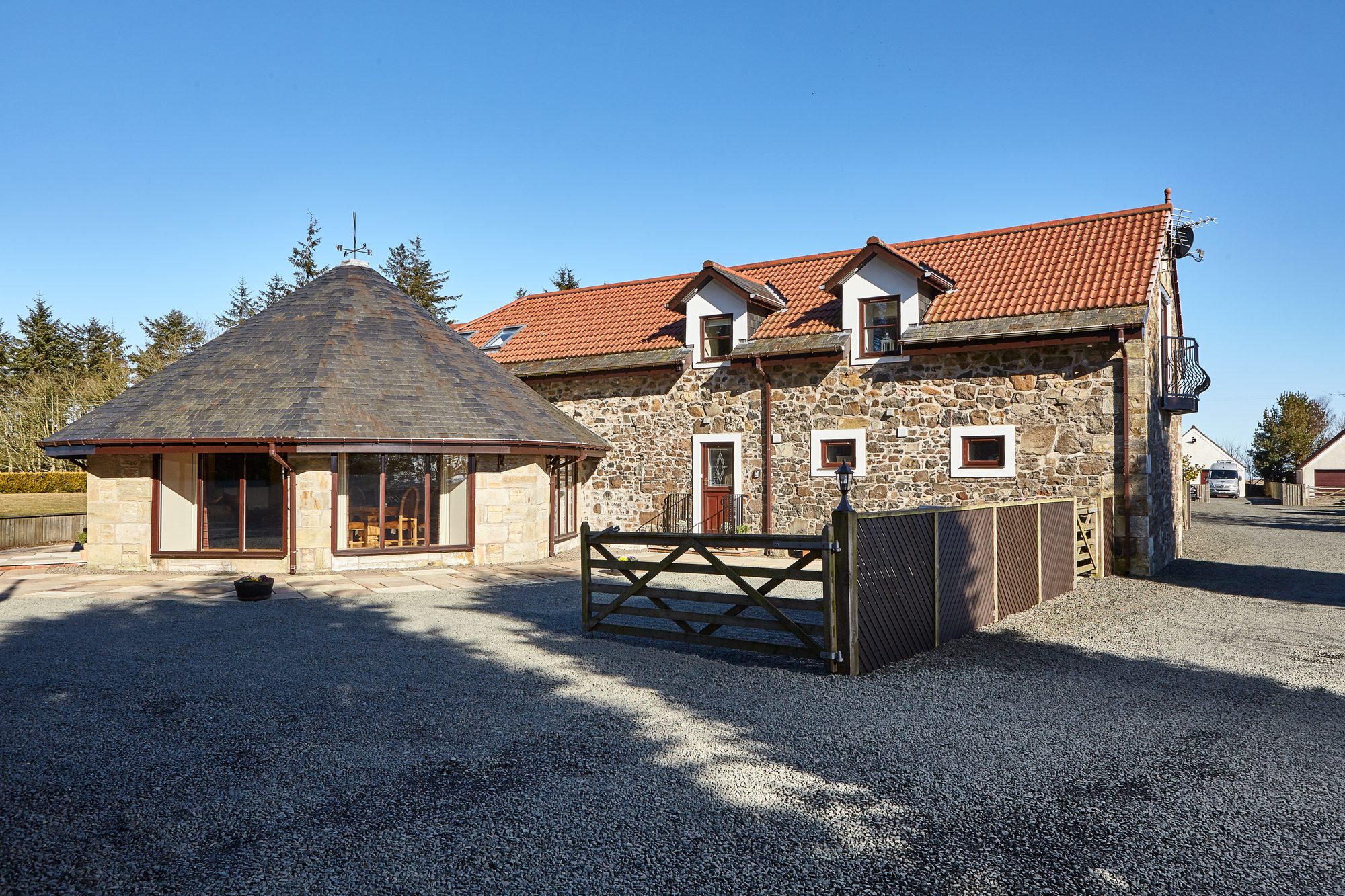 Writers Round House exterior with the circular round-house outbuilding and the main stone farmhouse